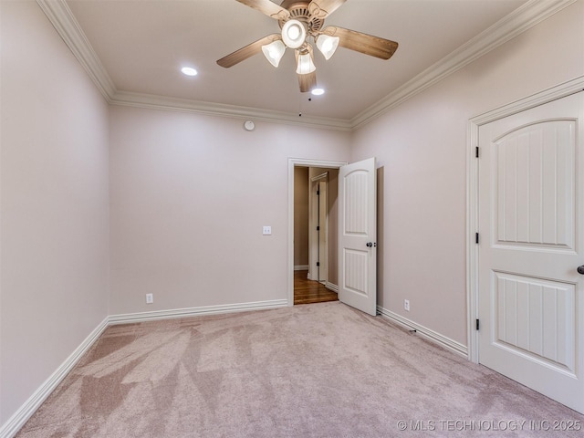 carpeted spare room featuring ornamental molding and ceiling fan