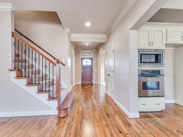 foyer entrance featuring ornamental molding and light hardwood / wood-style floors