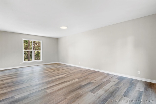 unfurnished room with light wood-style flooring and baseboards