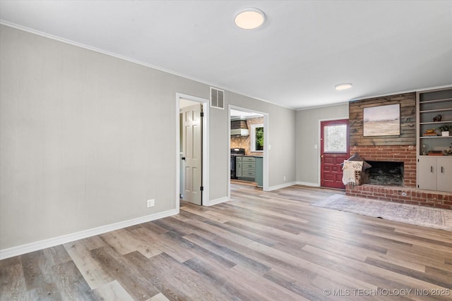 unfurnished living room with light wood finished floors, a fireplace, visible vents, and baseboards