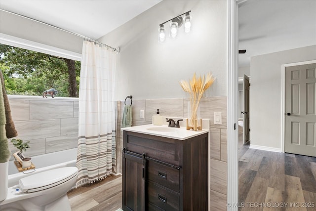 full bath with vanity, wood finished floors, tile walls, and shower / tub combo with curtain