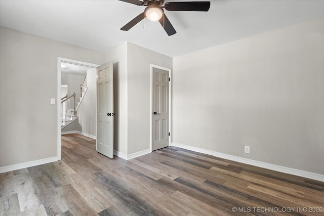 unfurnished bedroom featuring dark wood-style floors, ceiling fan, and baseboards