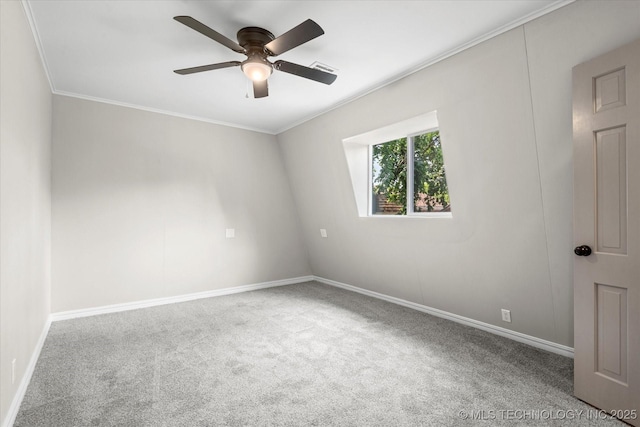 spare room with baseboards, visible vents, a ceiling fan, ornamental molding, and carpet floors