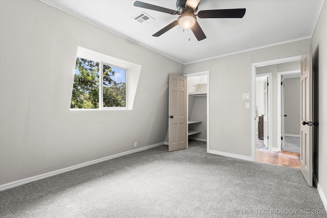 unfurnished bedroom featuring carpet, visible vents, baseboards, and ornamental molding