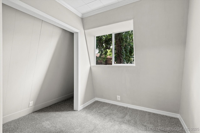 unfurnished bedroom with carpet, a closet, crown molding, and baseboards