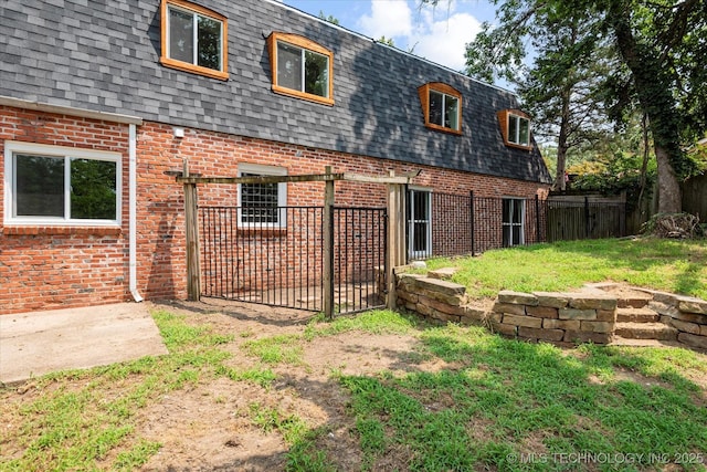 2936 Ridge Rd, Bartlesville, OK 74006 - rear view of property featuring mansard roof, a shingled roof, and brick siding