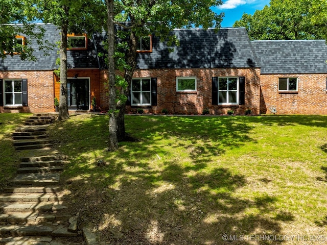 2936 Ridge Rd, Bartlesville, OK 74006 - view of front facade featuring brick siding, a shingled roof, a front lawn, mansard roof, and stairway
