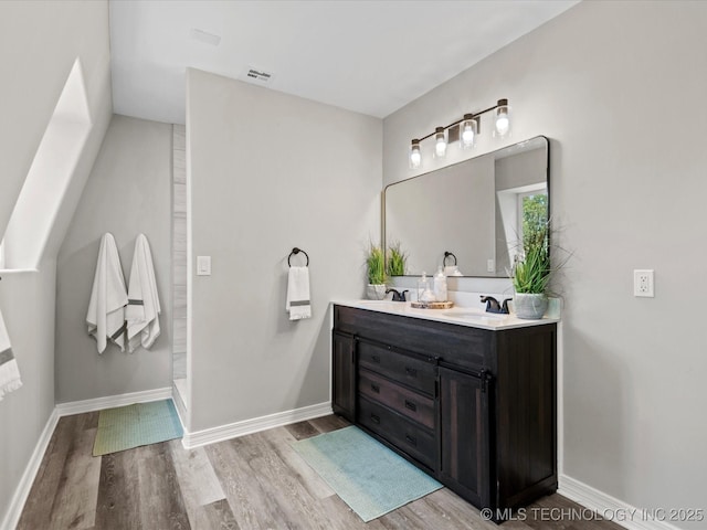 2936 Ridge Rd, Bartlesville, OK 74006 - bathroom featuring wood finished floors, double vanity, and baseboards