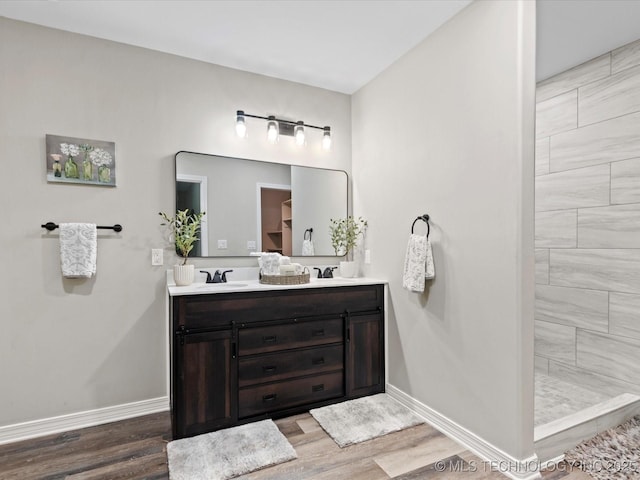 2936 Ridge Rd, Bartlesville, OK 74006 - full bath featuring wood finished floors, double vanity, baseboards, and tiled shower