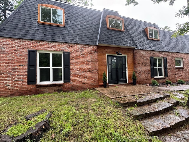 2936 Ridge Rd, Bartlesville, OK 74006 - view of front of house featuring roof with shingles, brick siding, mansard roof, a front yard, and a patio area
