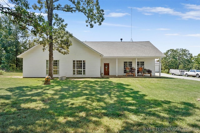 back of property with a lawn and a patio