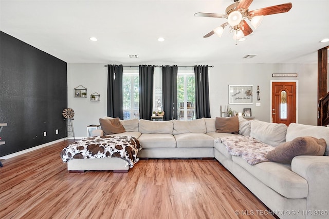 living room with ceiling fan and light wood-type flooring