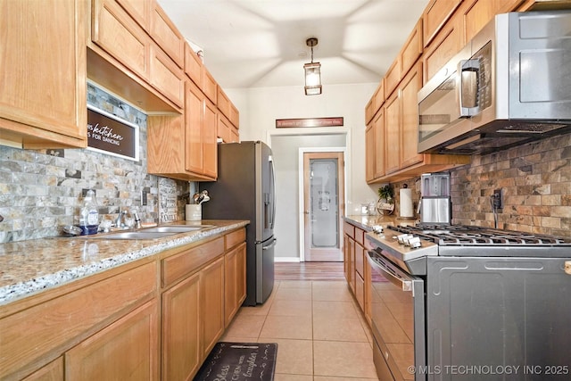 kitchen with light tile patterned floors, decorative backsplash, light stone countertops, and appliances with stainless steel finishes