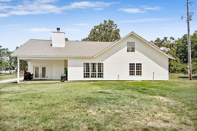 back of house featuring french doors and a lawn