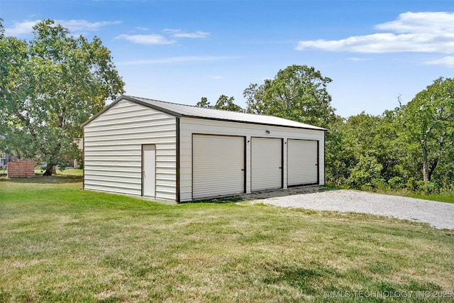 view of outdoor structure featuring a garage and a lawn