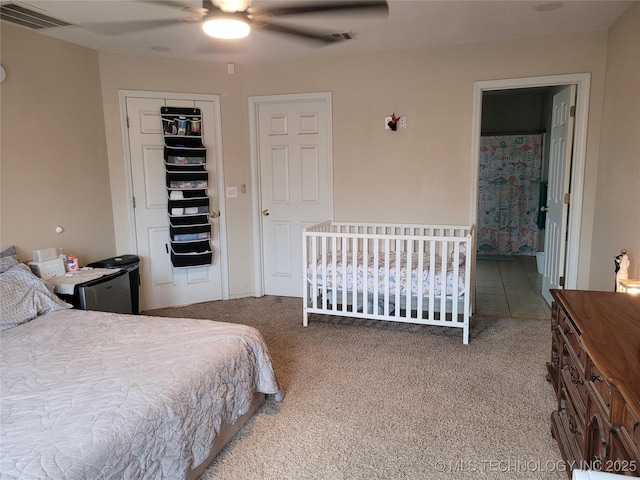 bedroom featuring ensuite bathroom, carpet flooring, ceiling fan, and a closet