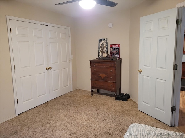 carpeted bedroom featuring ceiling fan and a closet