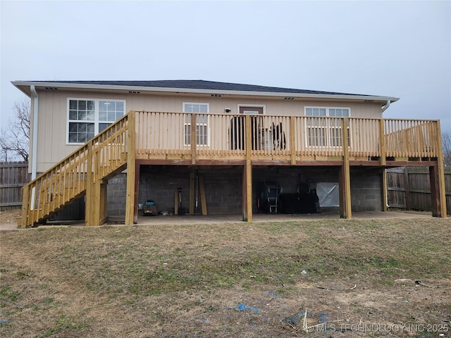 rear view of property with a wooden deck and a yard