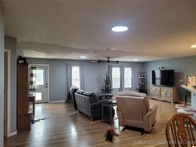 living room featuring hardwood / wood-style floors and ceiling fan