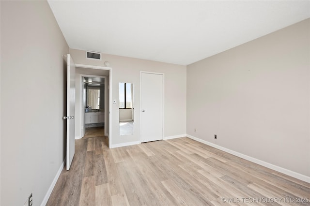 unfurnished bedroom featuring light hardwood / wood-style floors and a closet