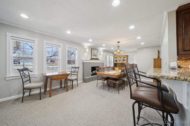 carpeted dining space with ornamental molding