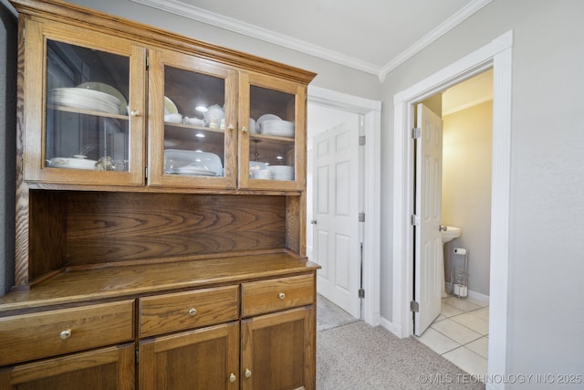 hall with ornamental molding and light tile patterned floors