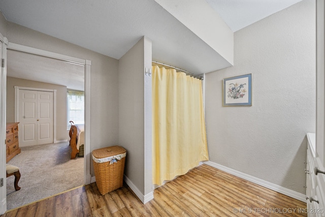 bathroom featuring wood-type flooring and vaulted ceiling