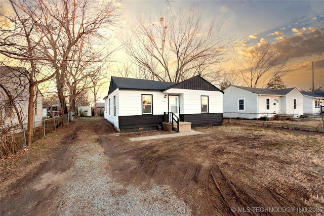 back of property with fence and crawl space
