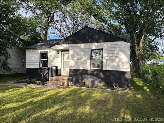 bungalow with a front lawn and fence