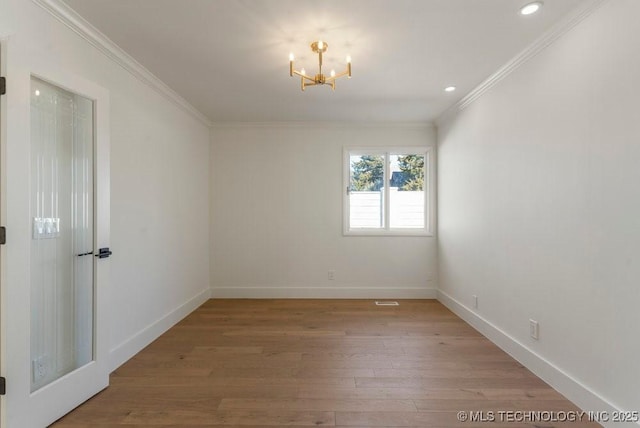 unfurnished room with crown molding, an inviting chandelier, and light hardwood / wood-style flooring