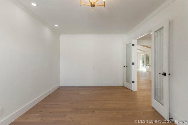 spare room with ornamental molding and light hardwood / wood-style floors