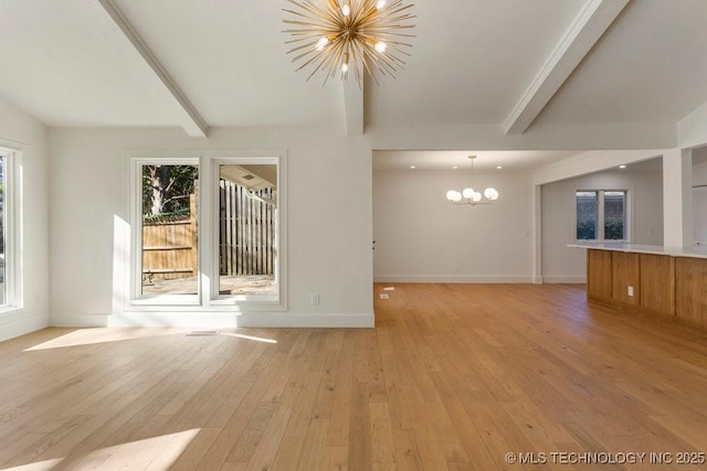 unfurnished living room with beamed ceiling, a healthy amount of sunlight, light hardwood / wood-style flooring, and a notable chandelier