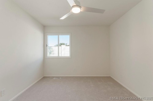 empty room featuring light colored carpet and ceiling fan