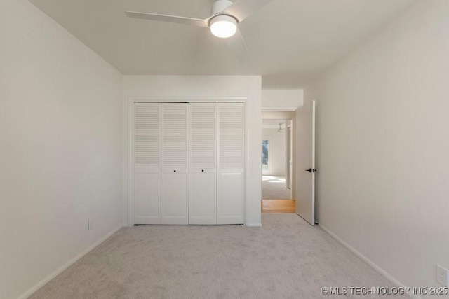 unfurnished bedroom with light carpet, ceiling fan, and a closet