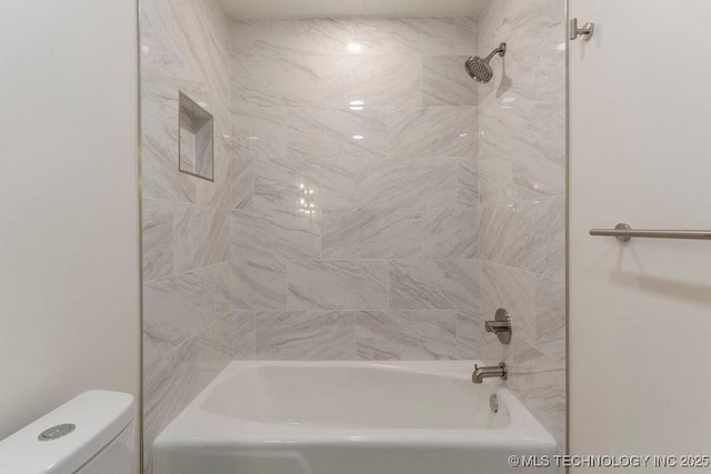 bathroom with toilet and tiled shower / bath combo