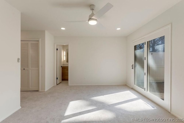 carpeted spare room featuring ceiling fan