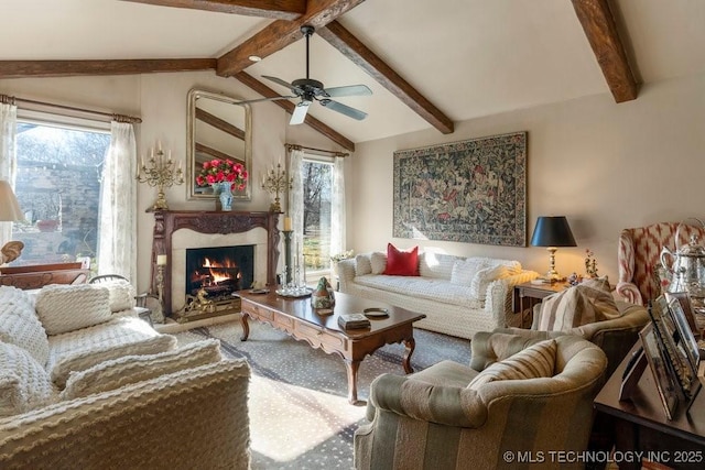 living room with lofted ceiling with beams, ceiling fan, a wealth of natural light, and a high end fireplace