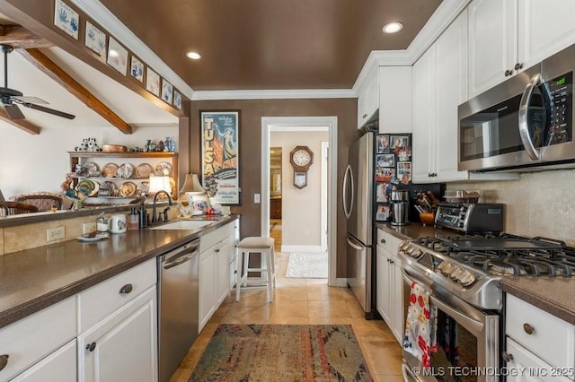 kitchen featuring light tile patterned flooring, beamed ceiling, white cabinetry, sink, and stainless steel appliances