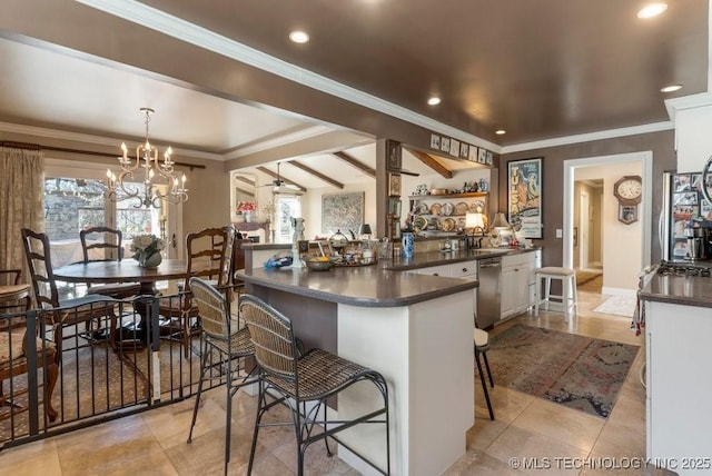 kitchen featuring pendant lighting, white cabinetry, a breakfast bar area, and dishwasher