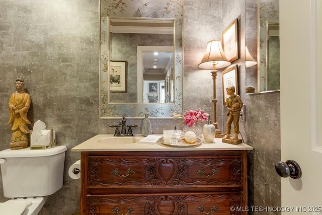 bathroom with crown molding, vanity, and toilet