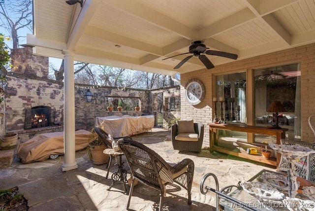 view of patio / terrace featuring an outdoor living space with a fireplace and ceiling fan