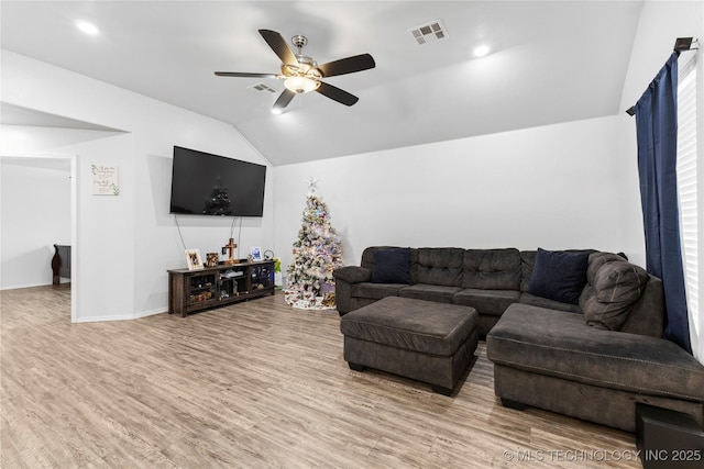 living room featuring ceiling fan, vaulted ceiling, and light wood-type flooring