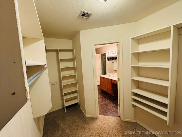 walk in closet featuring dark carpet and visible vents