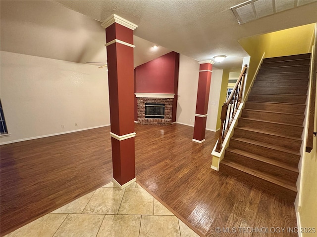 below grade area featuring stairs, a brick fireplace, and wood finished floors