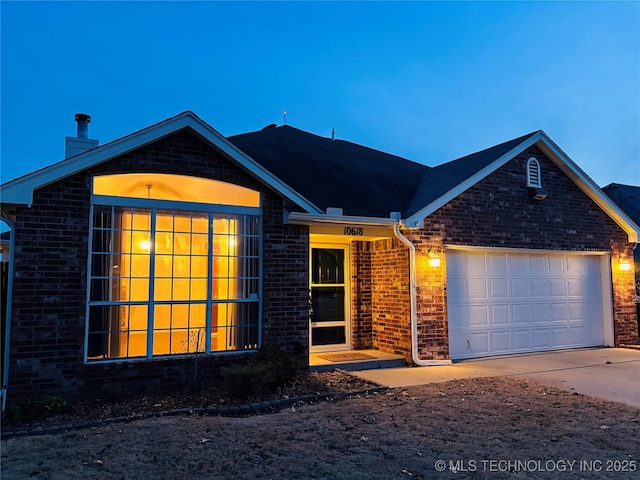 ranch-style house featuring a garage, concrete driveway, brick siding, and a chimney