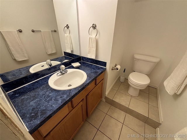 bathroom featuring toilet, tile patterned flooring, baseboards, and vanity