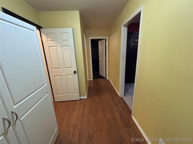 hall with baseboards and wood finished floors