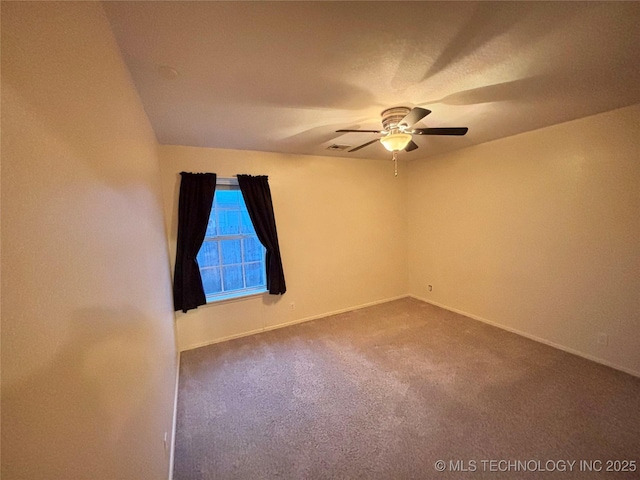 unfurnished room with visible vents, dark carpet, baseboards, and ceiling fan