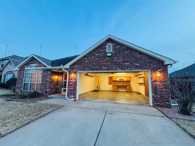 ranch-style house featuring a garage, brick siding, and driveway