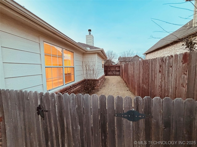 view of yard featuring radiator heating unit, fence, and a gate